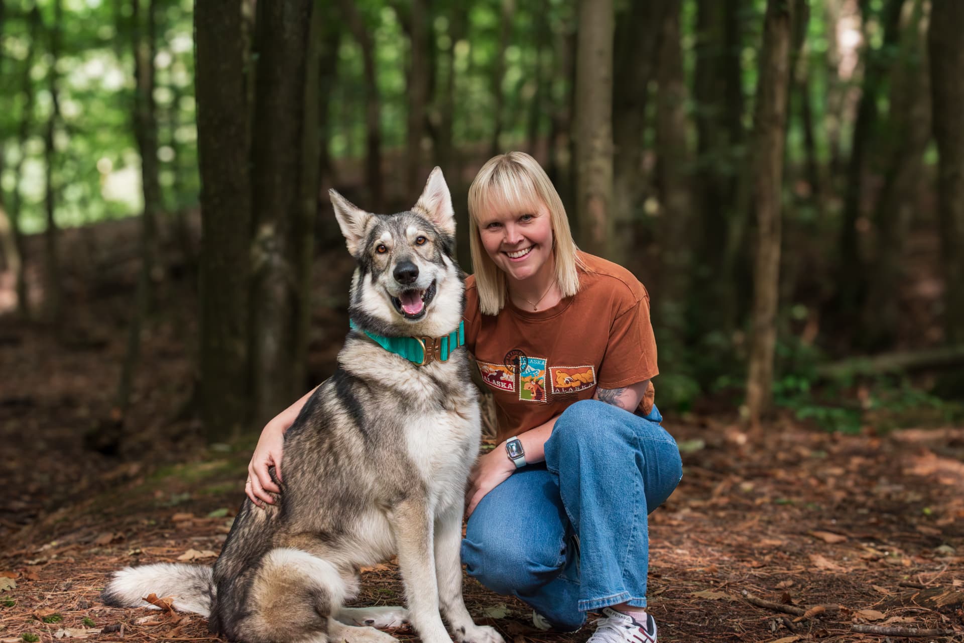 Woman sitting with her dog in woodland